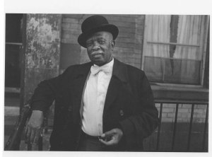 Photograph of man in Harlem wearing a bowler hat.